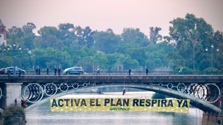Escaladores de Greenpeace se descuelgan con una pancarta en el puente de Triana